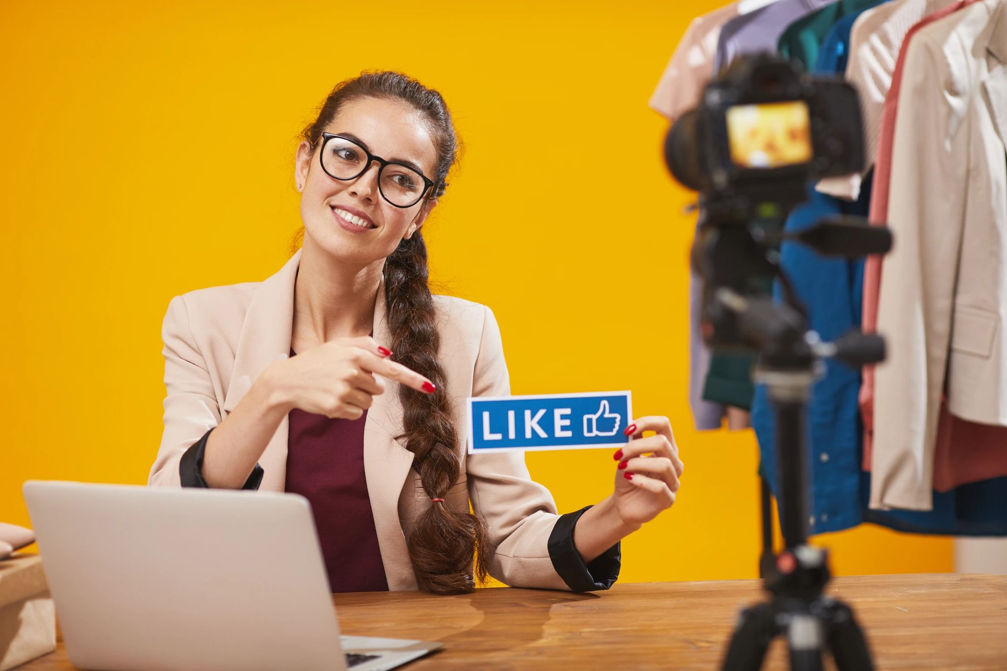 Frau hält ein Schild mit der Beschriftung "Like" in die Kamera